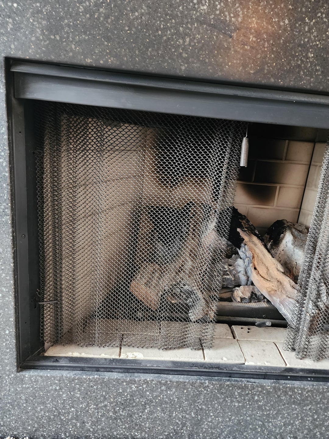 ogień buzujący w kominku z widocznym szyberem